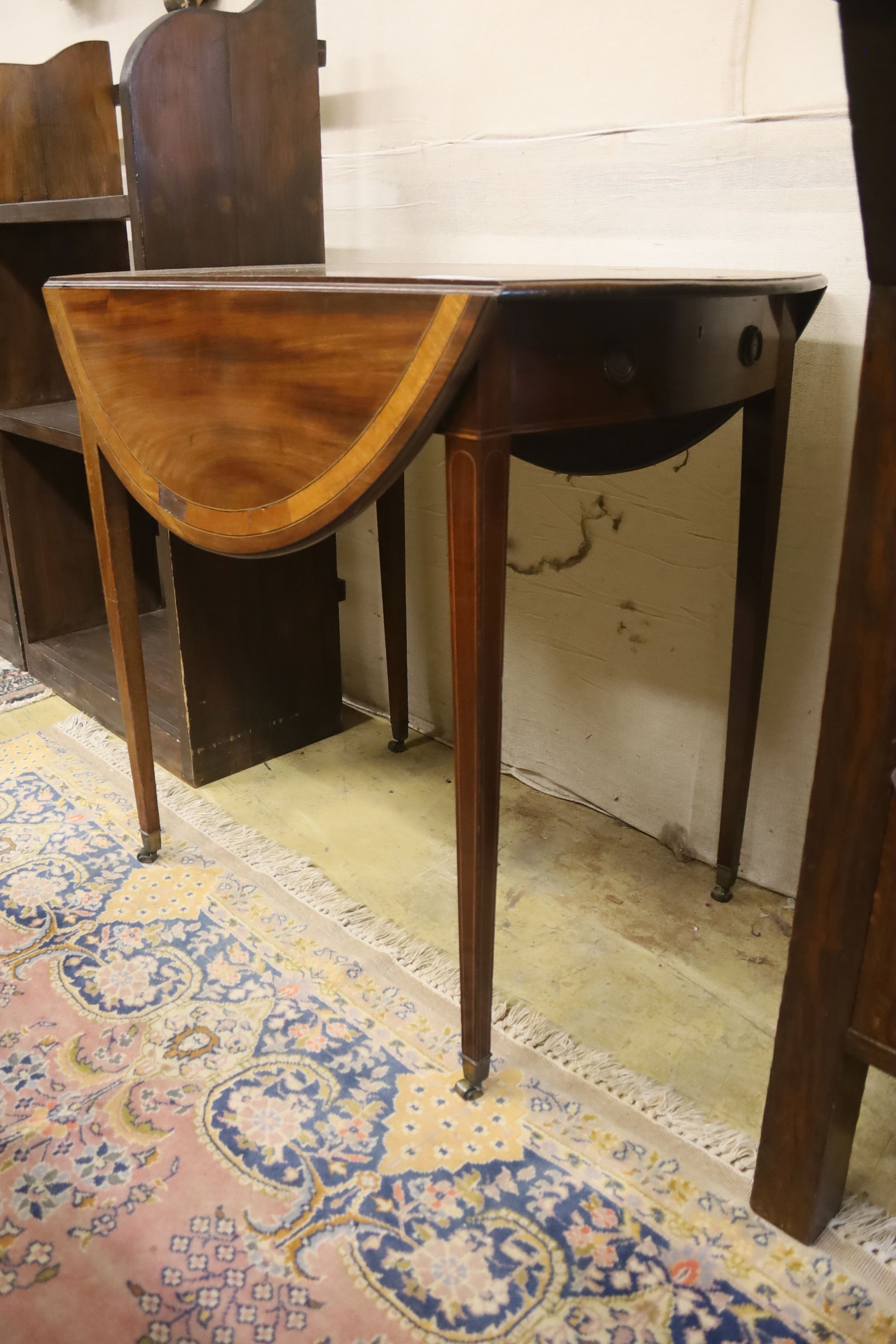 A George III mahogany and satinwood banded oval topped Pembroke table, width 79cm, depth 52cm, height 74cm